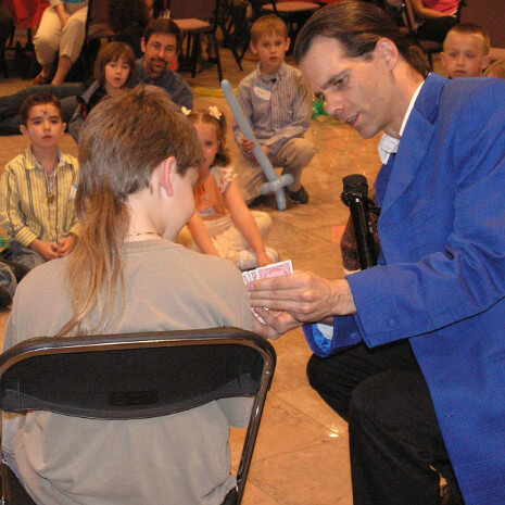 A Chicago boy helps the magician with a card trick during local area magic show!